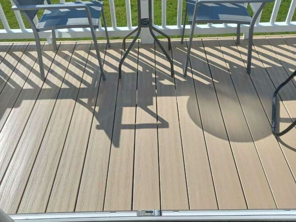 a deck with wood-like flooring and blue chairs at Skegness Holiday Park - Holiday Accommodation 13968 in Skegness