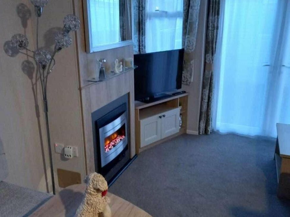a living room with a fireplace and a television at Skegness Holiday Park - Holiday Accommodation 13968, Skegness