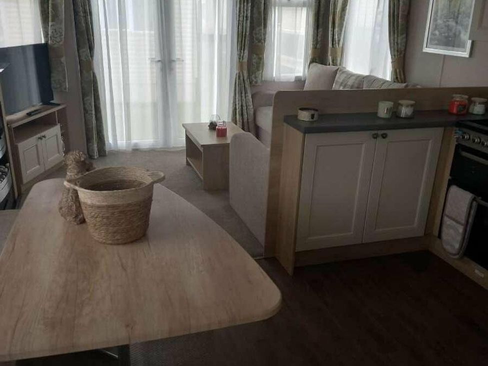 a living area with a table, basket, and kitchen area at Skegness Holiday Park - Holiday Accommodation 13968 in Skegness