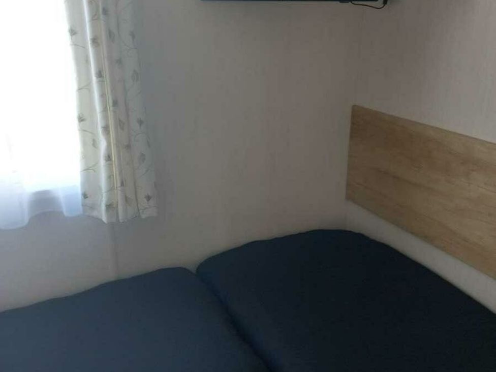 a bedroom with a bed and a television mounted on the wall at Skegness Holiday Park - Holiday Accommodation 13968 in Skegness