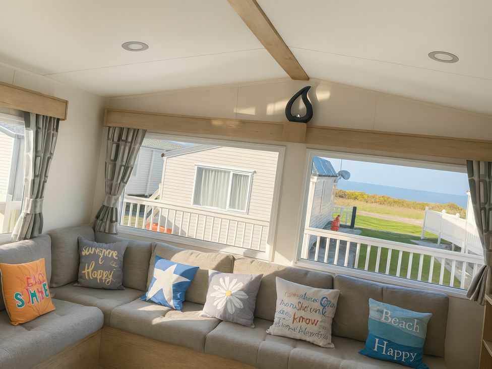 A living room with cushions on a sofa at Reighton Sands Holiday Park - Holiday Accommodation 14875, Filey