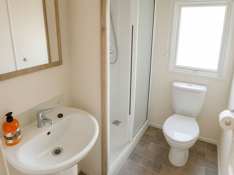 A bathroom with a wash basin and shower cabin at Reighton Sands Holiday Park - Holiday Accommodation 14875, Filey