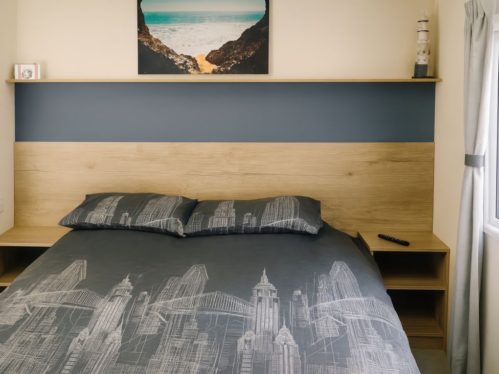 A bedroom with a bed and bedside table at Reighton Sands Holiday Park - Holiday Accommodation 14875 in Filey