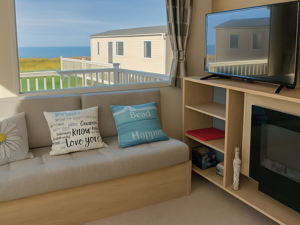 A living room with a sofa and television at Reighton Sands Holiday Park - Holiday Accommodation 14875, Filey