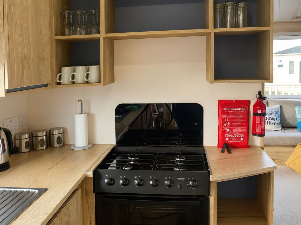 A kitchen with an oven, mugs and utensils at Reighton Sands Holiday Park - Holiday Accommodation 14875, Filey