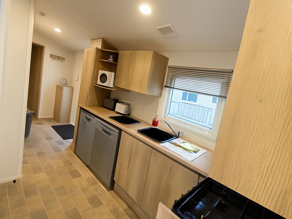 A kitchen with a sink and stove at Reighton Sands Holiday Park - Holiday Accommodation 14875, Filey