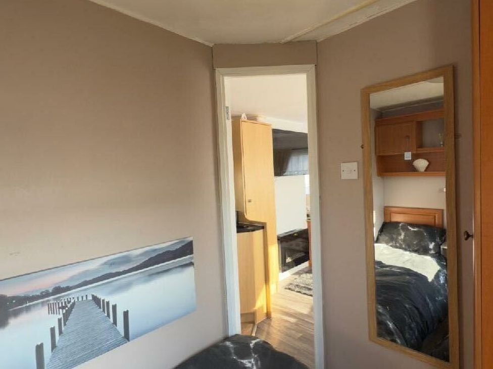 a room with a mirror and a view of a pier on the wall at Sealands Caravan Park - Holiday Accommodation 15223 in Ingoldmells