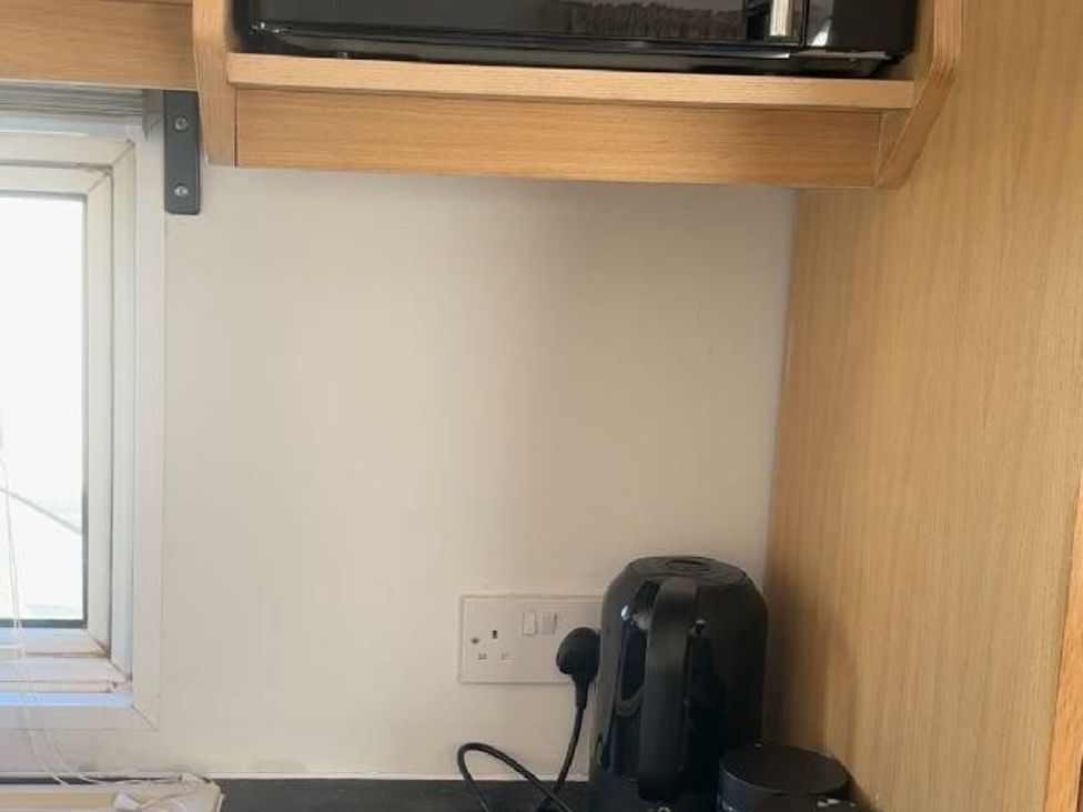 a kitchen corner with a microwave and coffee maker at Sealands Caravan Park - Holiday Accommodation 15223 in Ingoldmells