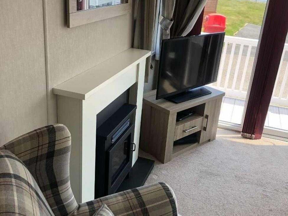 a living room with a fireplace and a television at Hopton Holiday Village - Holiday Accommodation 15473 Great Yarmouth