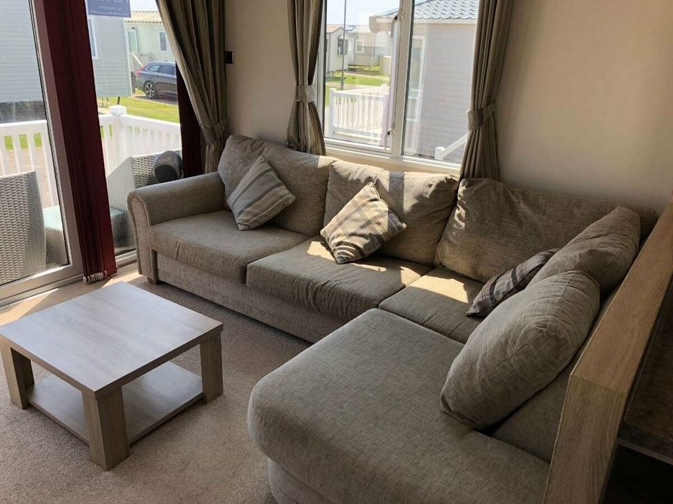 a living room with a sectional sofa and a coffee table at Hopton Holiday Village - Holiday Accommodation 15473, Great Yarmouth