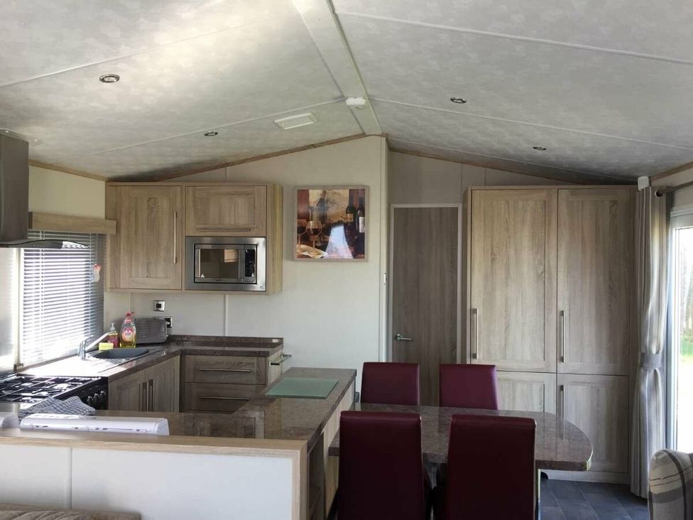 a kitchen and dining area with a table and chairs at Hopton Holiday Village - Holiday Accommodation 15473, Great Yarmouth
