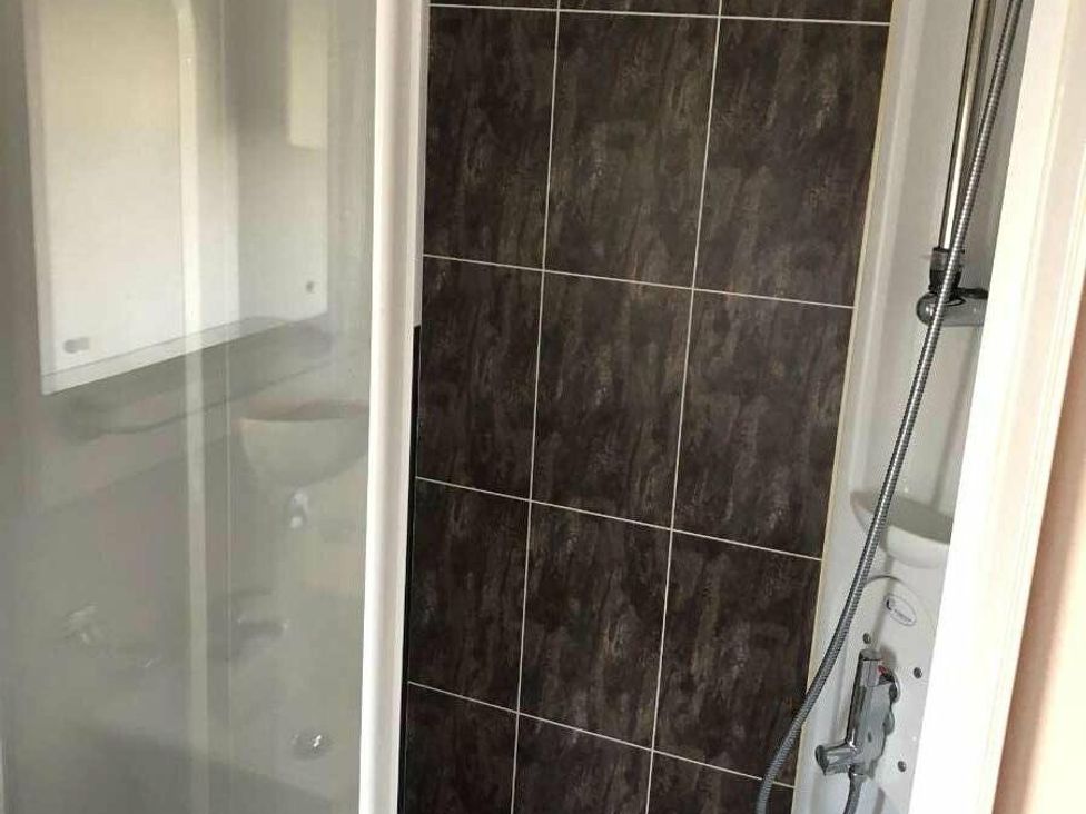 a shower unit with tiled walls and a shower head at Hopton Holiday Village - Holiday Accommodation 15473 in Great Yarmouth