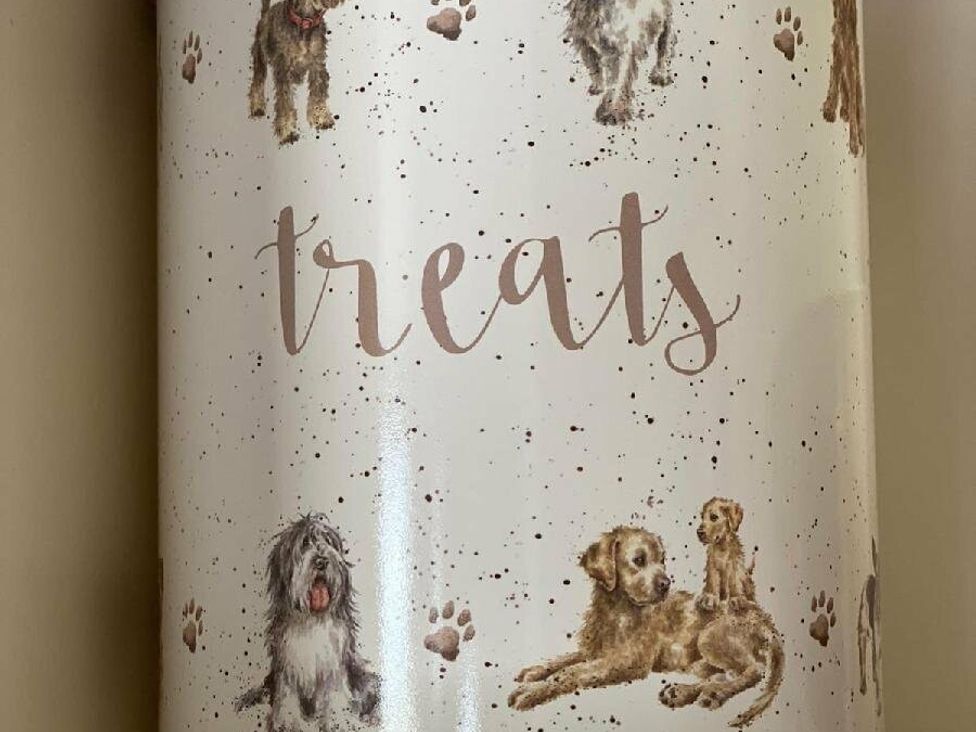 a canister labeled treats with illustrations of various dogs and paw prints at Lyons Sunnysands Holiday Park - Holiday Accommodation 15526, Barmouth