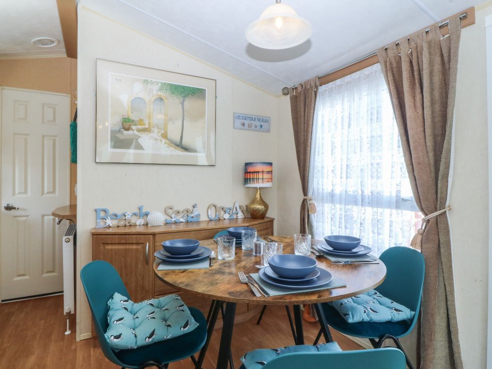 A dining room with a table set for four at Sunnysands in Talybont near Barmouth