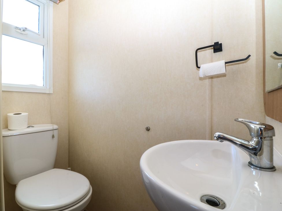 A bathroom with a toilet and sink at Sunnysands in Talybont near Barmouth