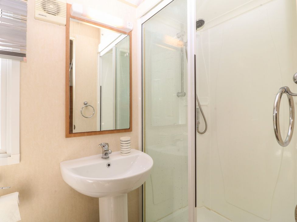 A bathroom with a sink and shower at Sunnysands in Talybont near Barmouth