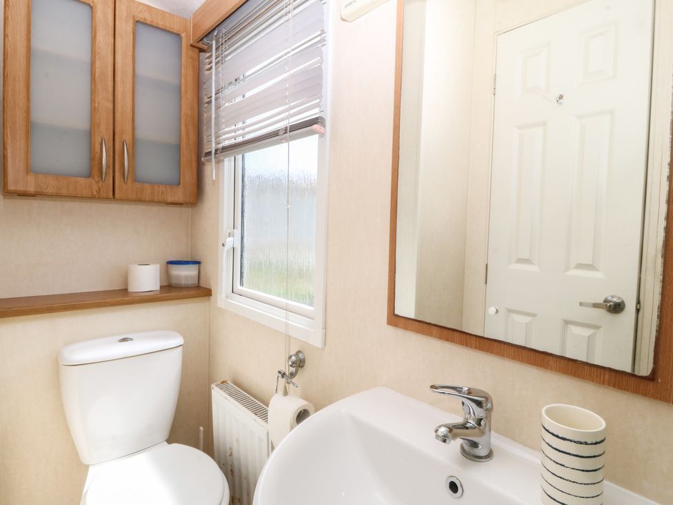 A bathroom with a sink and toilet at Sunnysands Talybont near Barmouth