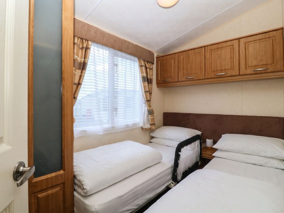 A bedroom with two beds and a window at Sunnysands in Talybont near Barmouth