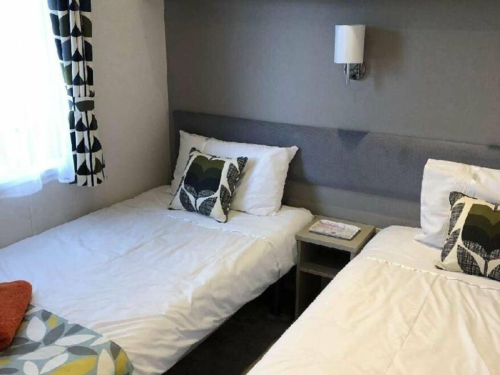 a bedroom with two single beds and a bedside table at Shorefield Country Park - Holiday Accommodation 15558 in Milford On Sea