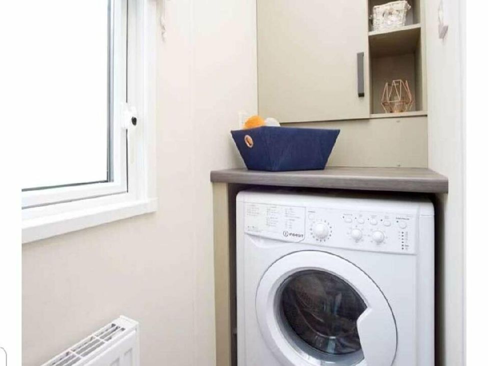 a laundry area with a washing machine and a shelf at Shorefield Country Park - Holiday Accommodation 15558, Milford On Sea