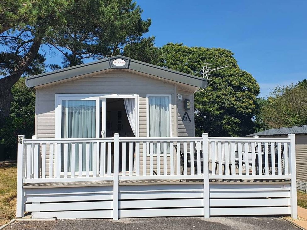 a vacation home with a deck and large front windows at Shorefield Country Park - Holiday Accommodation 15558 Milford On Sea