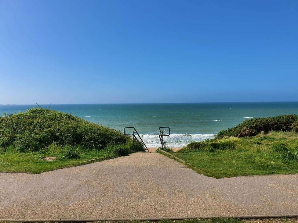 a view of the sea from a pathway with grass on either side at Shorefield Country Park - Holiday Accommodation 15558 Milford On Sea