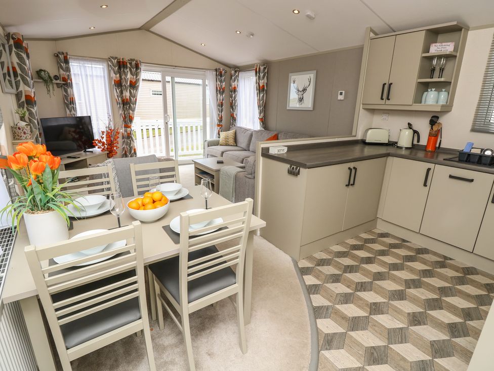 A living room with dining area and kitchen at Pine Tree Lodge - Shorefield Country Park Milford On Sea