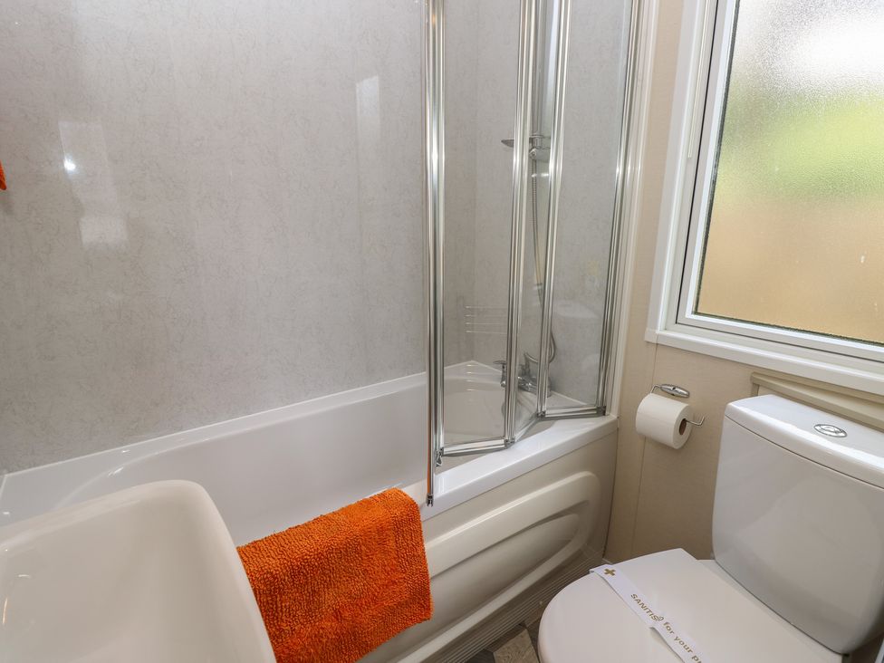 A bathroom with a bath tub and shower at Pine Tree Lodge - Shorefield Country Park, Milford On Sea