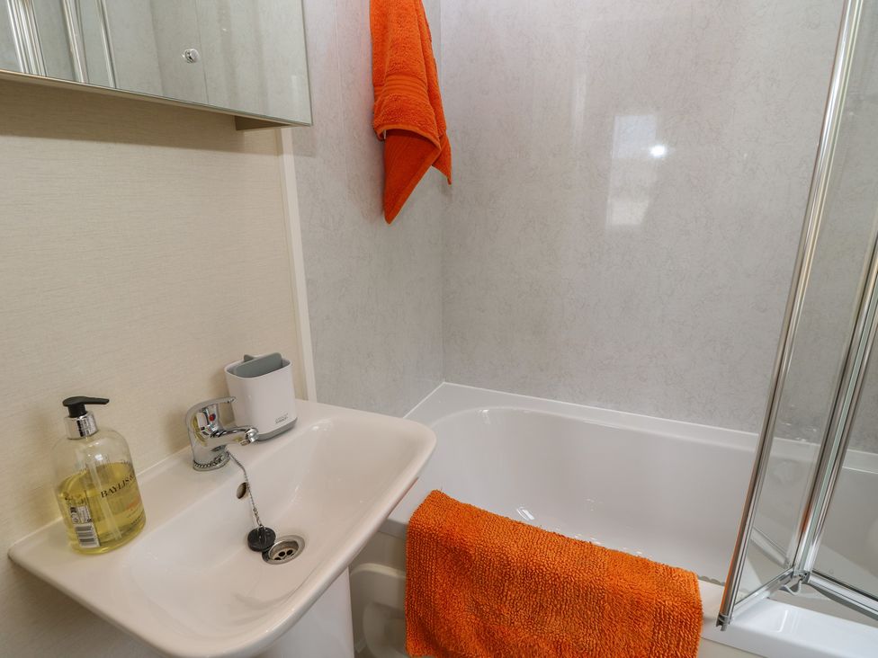 A bathroom with a bath tub and sink at Pine Tree Lodge - Shorefield Country Park, Milford On Sea