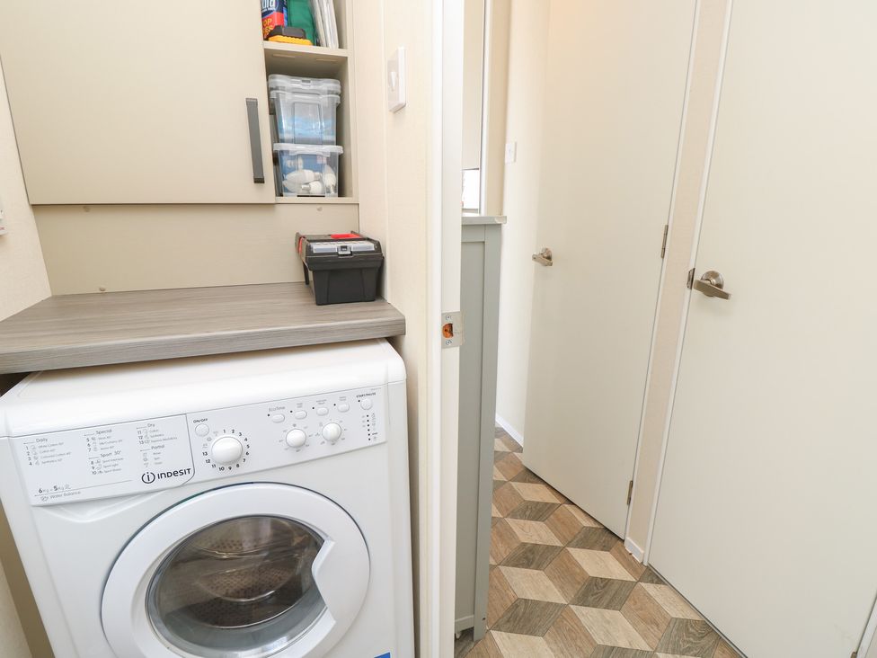 A laundry room with a washing machine and storage at Pine Tree Lodge - Shorefield Country Park Milford On Sea