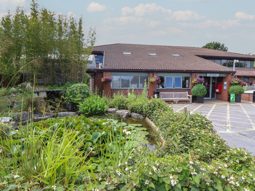 A reception area with pond and plants at Pine Tree Lodge - Shorefield Country Park in Milford On Sea