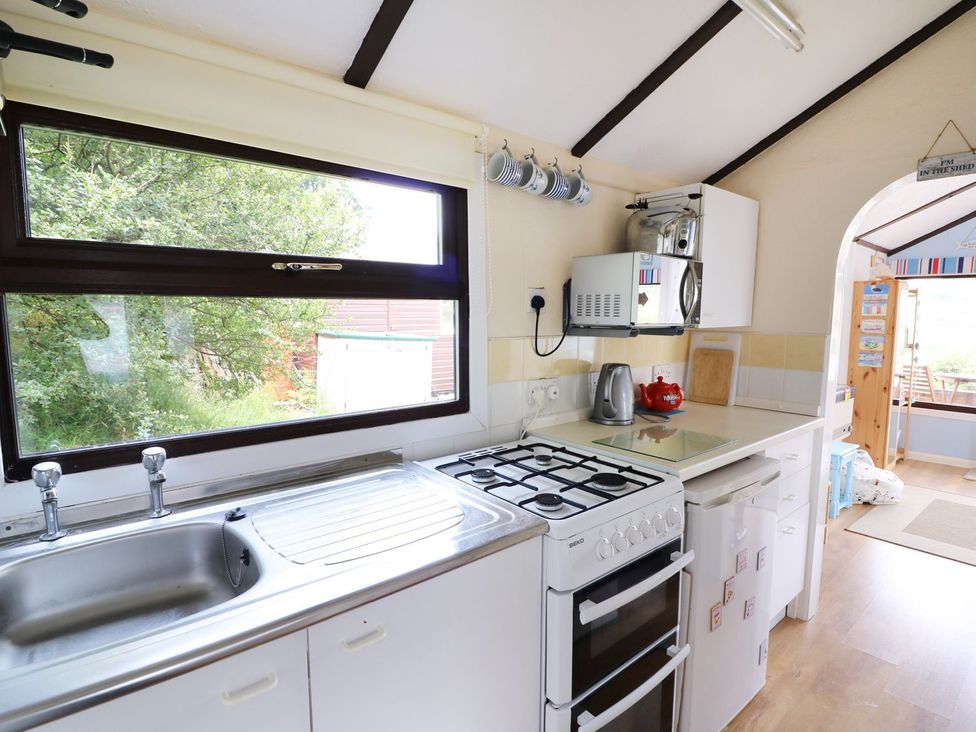 A kitchen with a sink and stove at Captain's Cabin in Clarach Bay near Aberystwyth
