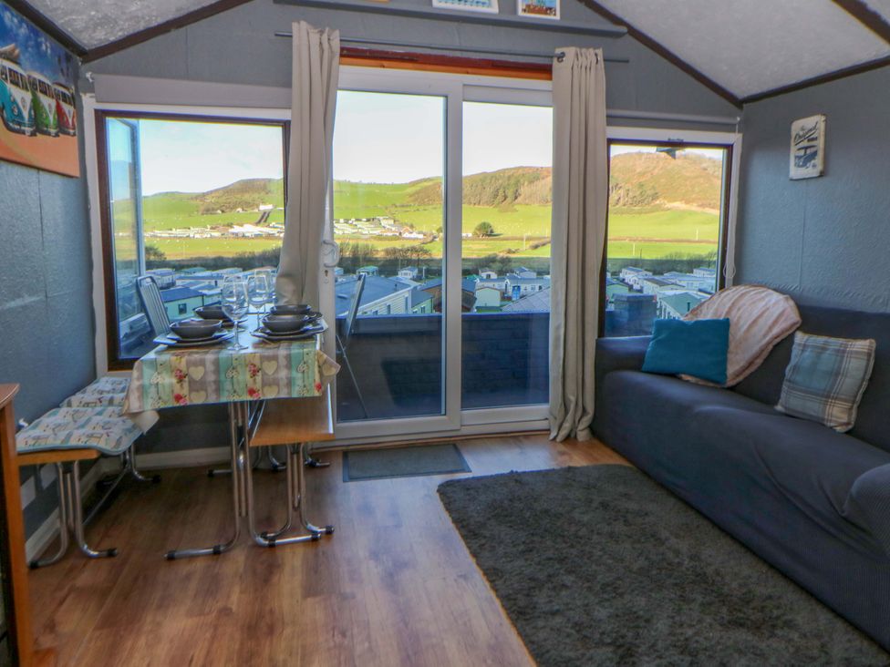 A living room with a table and chairs at Captain's Cabin in Clarach Bay near Aberystwyth