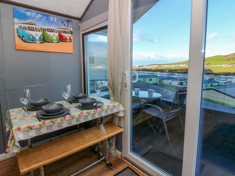 A dining room with a table and chairs at Captain's Cabin in Clarach Bay near Aberystwyth