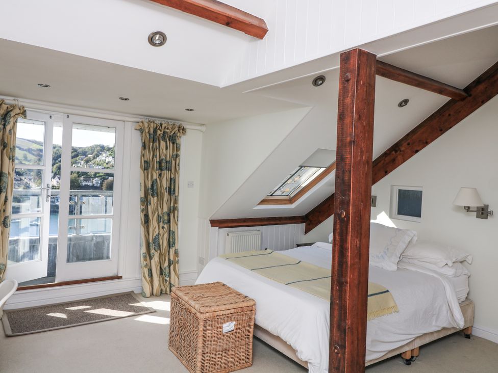 A bedroom with a bed and balcony window at Fastnet at Nonsuch House in Kingswear, Devon