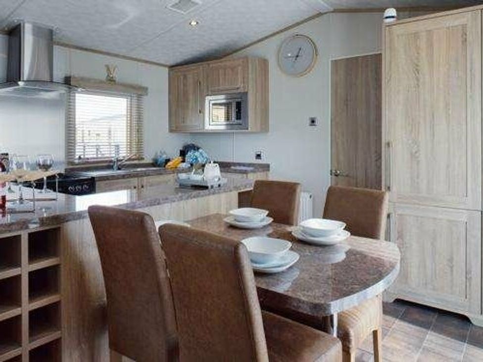a kitchen and dining area with a table set for four at Tattershall Lakes Country Park - Holiday Accommodation 16408, Tattershall