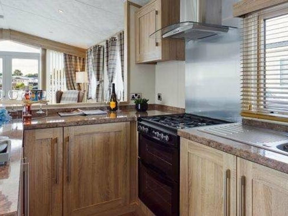a kitchen with wooden cabinetry and a gas stove at Tattershall Lakes Country Park - Holiday Accommodation 16408, Tattershall
