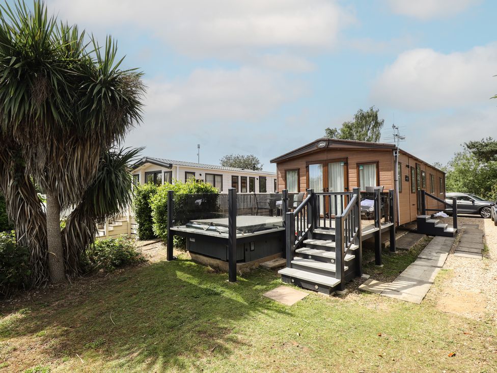 An outdoor area with a caravan and hot tub at Tattershall Lakes Country Park - Holiday Accommodation 16408 Tattershall