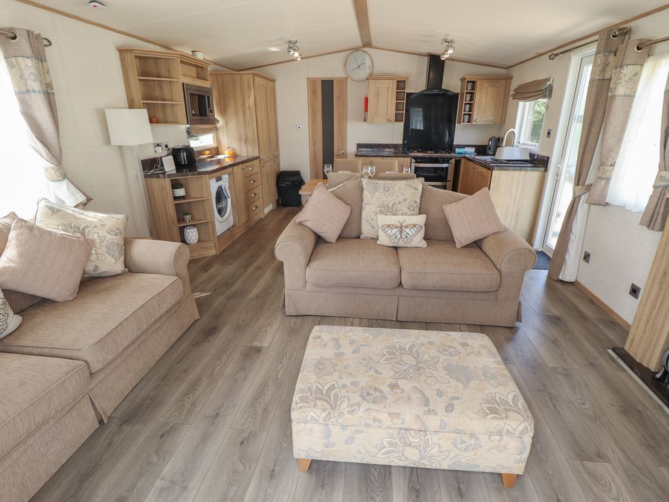 A living room with sofas and a kitchen area at Tattershall Lakes Country Park - Holiday Accommodation 16408 in Tattershall