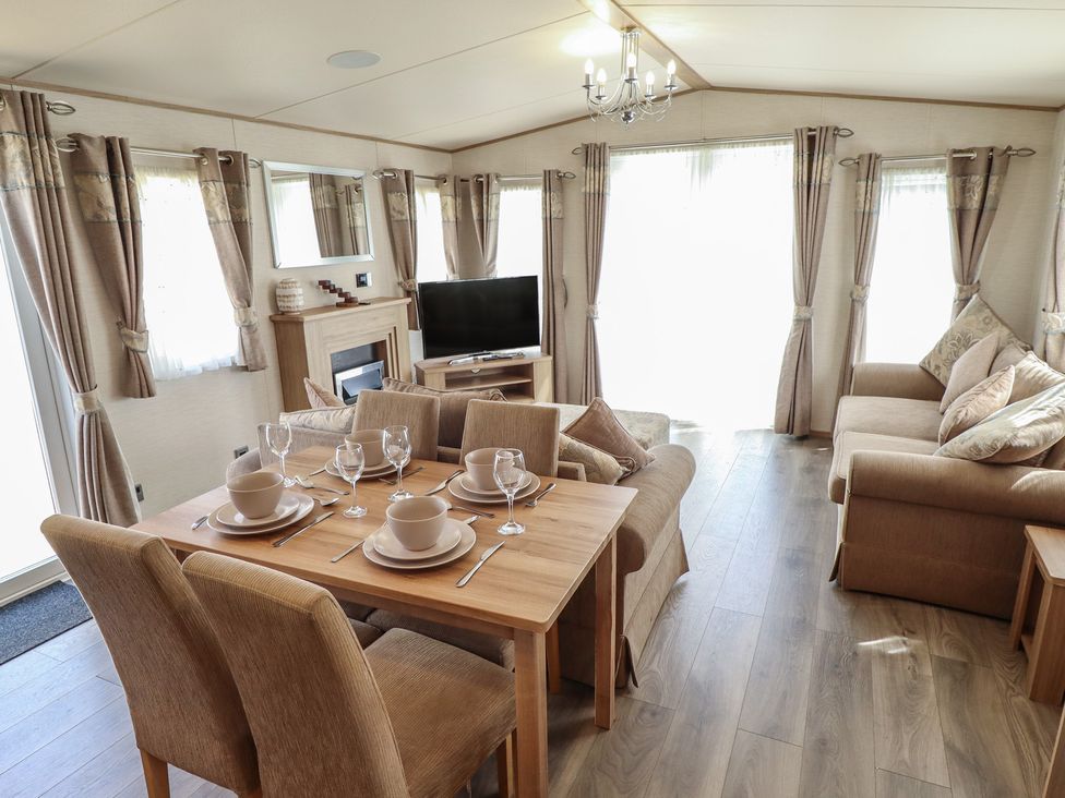 A living room with a sofa, dining table and television at Tattershall Lakes Country Park - Holiday Accommodation 16408, Tattershall