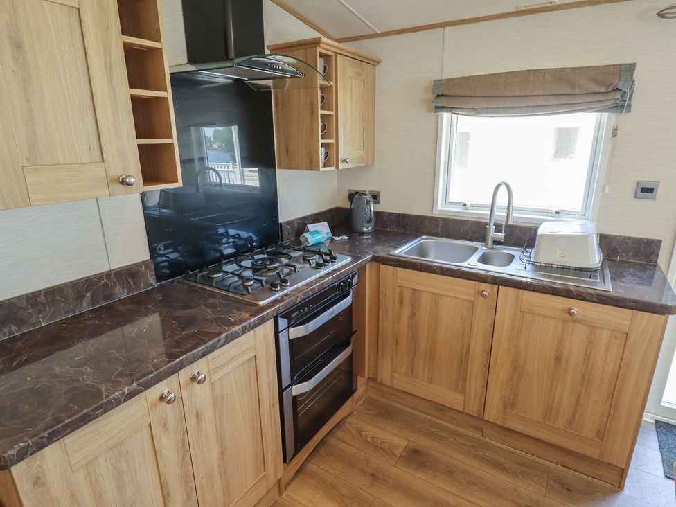 A kitchen with a gas stove and sink at Tattershall Lakes Country Park - Holiday Accommodation 16408 Tattershall