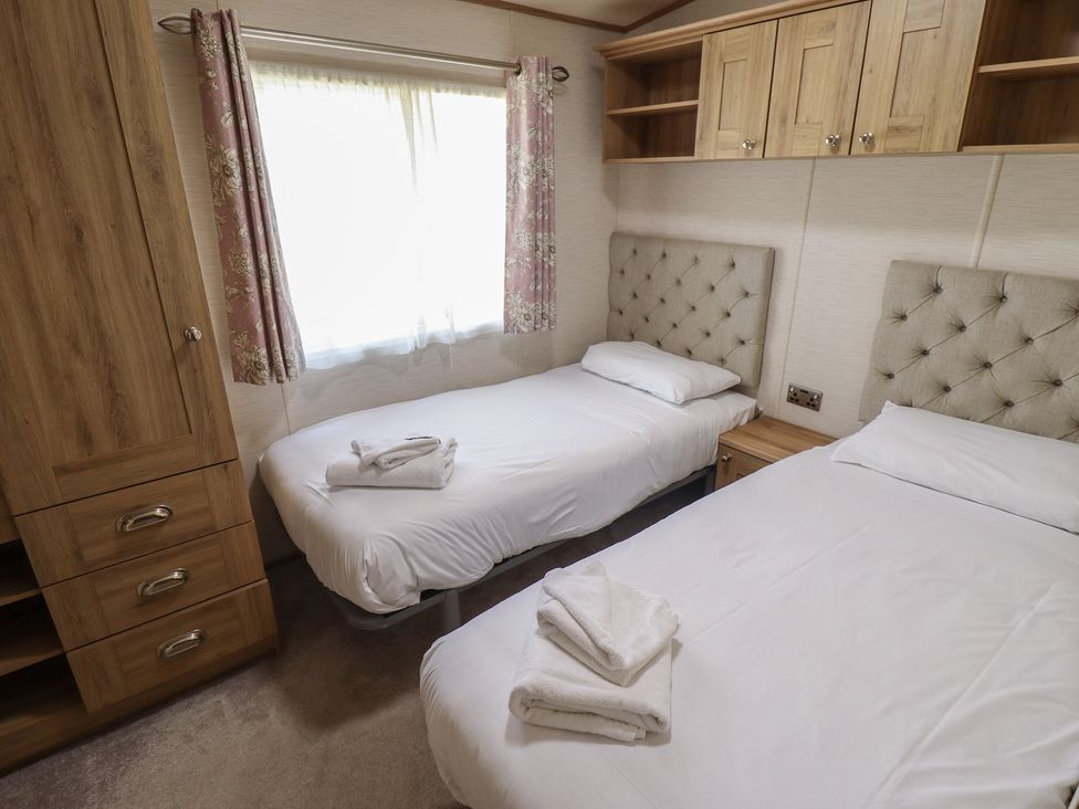 A bedroom with twin beds and a cabinet at Tattershall Lakes Country Park - Holiday Accommodation 16408 Tattershall