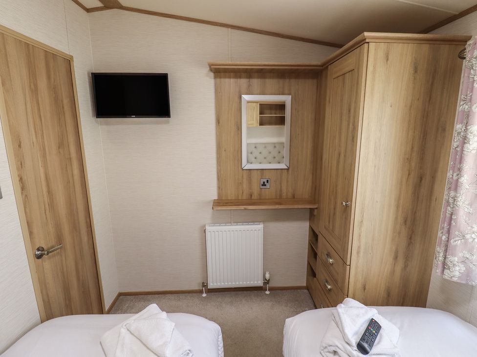 A bedroom with a television, wardrobe, and mirror at Tattershall Lakes Country Park - Holiday Accommodation 16408, Tattershall