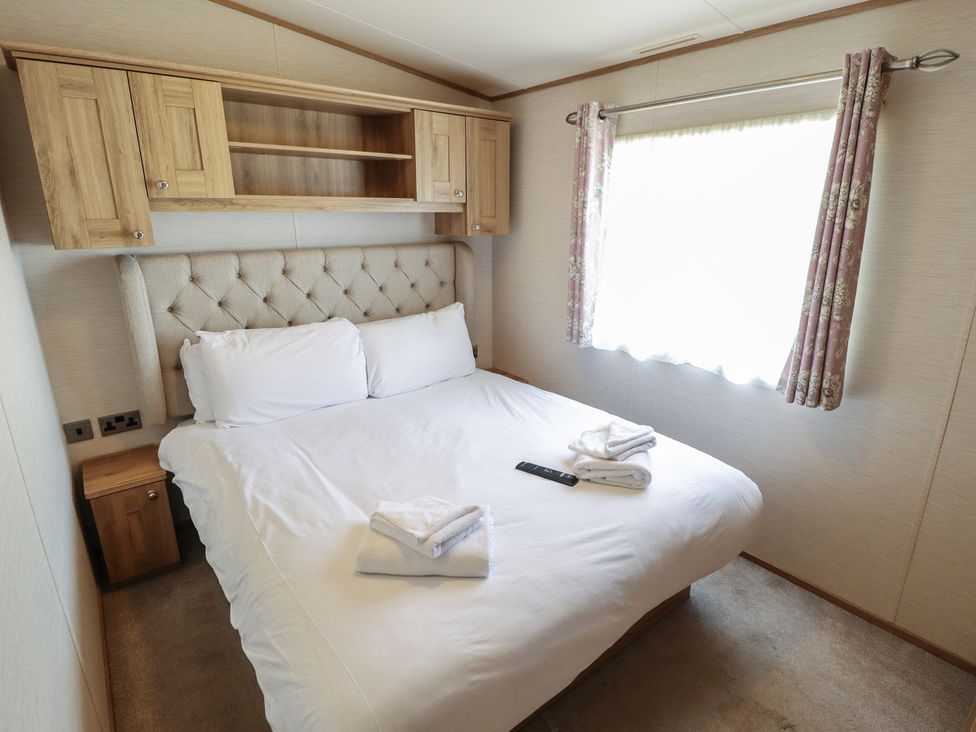 A bedroom with a double bed and shelves at Tattershall Lakes Country Park - Holiday Accommodation 16408, Tattershall