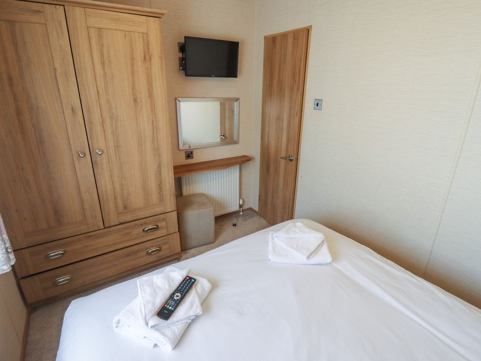 A bedroom with a wardrobe and television at Tattershall Lakes Country Park - Holiday Accommodation 16408, Tattershall