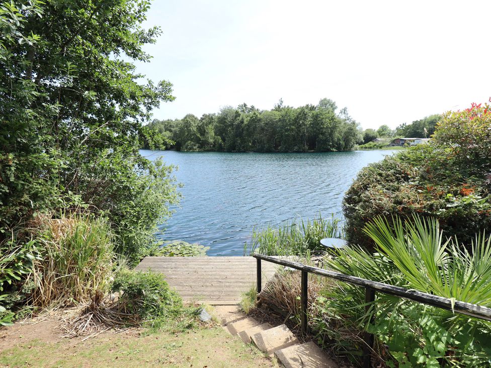A dock leading to a water body surrounded by trees at Tattershall Lakes Country Park - Holiday Accommodation 16408, Tattershall