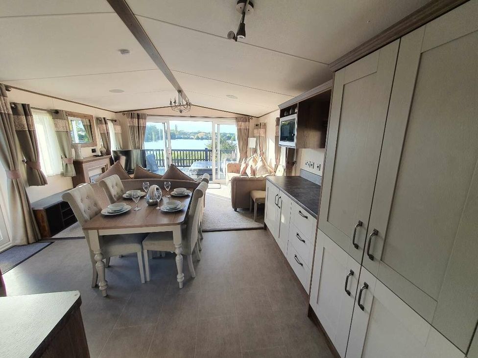 an open-plan dining and living area with a table and chairs at Tattershall Lakes Country Park - Holiday Accommodation 16605 in Tattershall