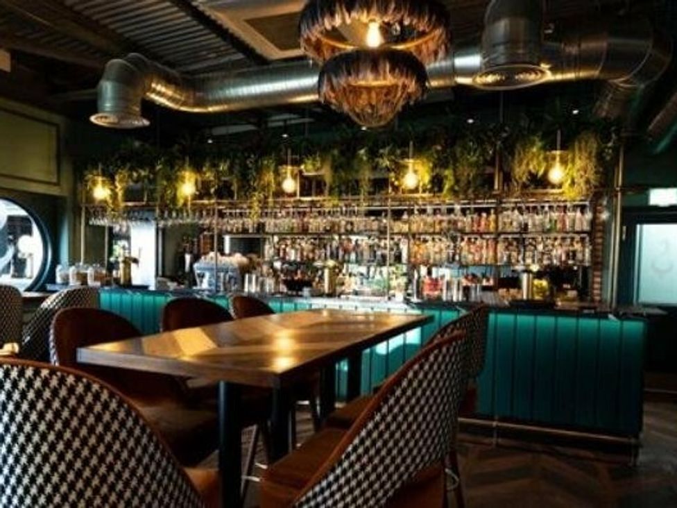 a bar with a wooden table and patterned chairs at Tattershall Lakes Country Park - Holiday Accommodation 16605, Tattershall