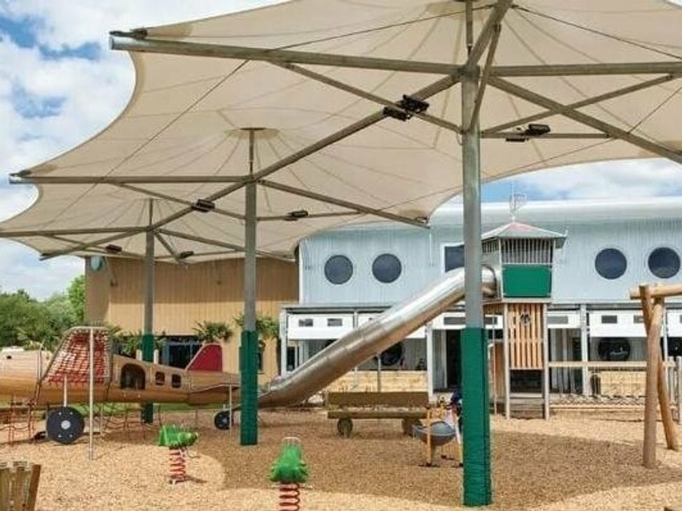 a playground with a slide and climbing structure under shaded canopies at Tattershall Lakes Country Park - Holiday Accommodation 16605 Tattershall