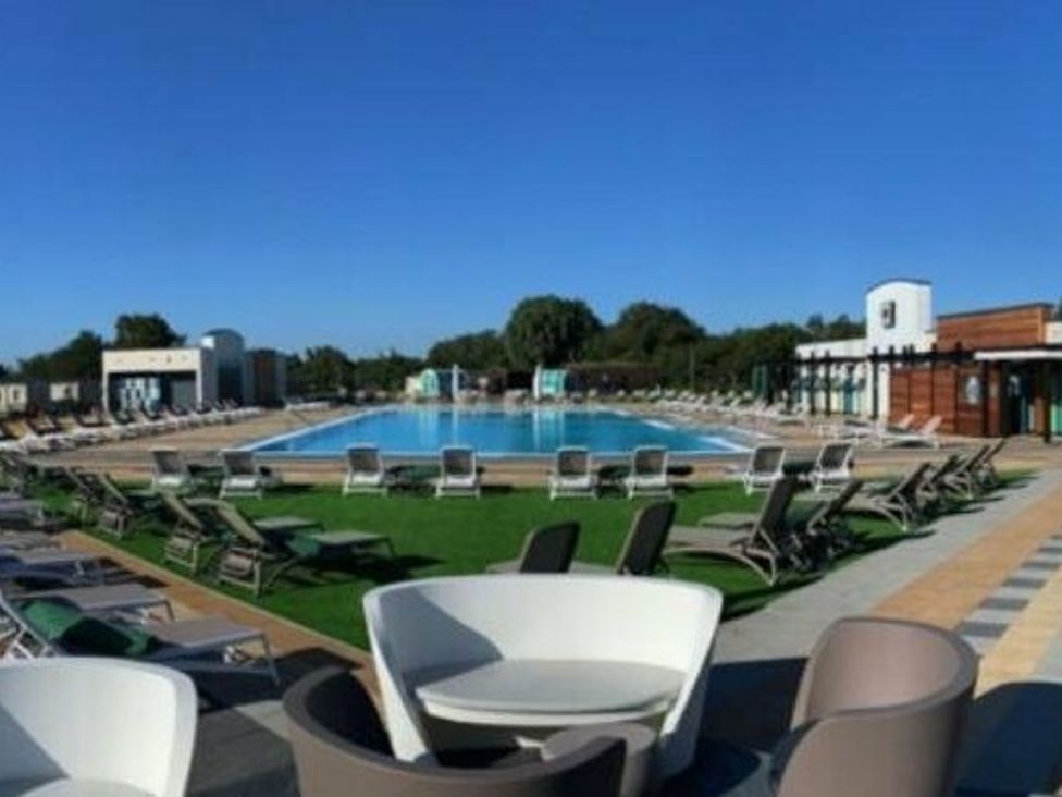 a swimming pool surrounded by lounge chairs at Tattershall Lakes Country Park - Holiday Accommodation 16605 in Tattershall